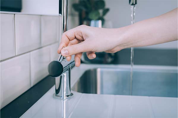 Plumber fixing a dripping bathroom faucet